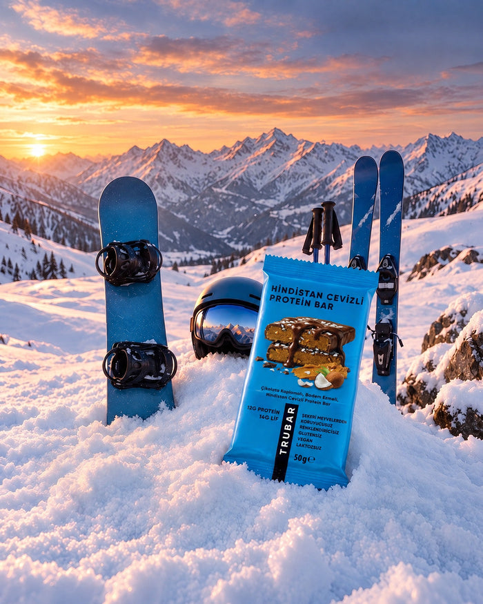 Kar üstünde snowboard ekipmanları ve TRUBAR Hindistan Cevizli Protein Bar