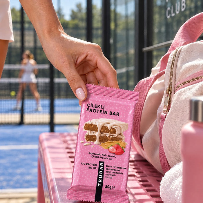 Padel kortunda çantasından TRUBAR Çilekli Protein Bar alan sporcu